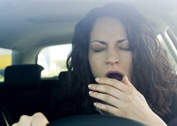Женщина зевает за рулем
